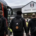 Editorial illustration of Manchester United players seen from behind arriving at Craven Cottage with the team coach before the Fulham match.