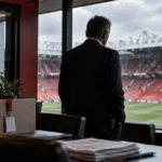 Editorial illustration of a football executive overlooking a red-seated stadium beside packed office boxes and a closed staff area, representing Manchester United's cost-cutting programme.